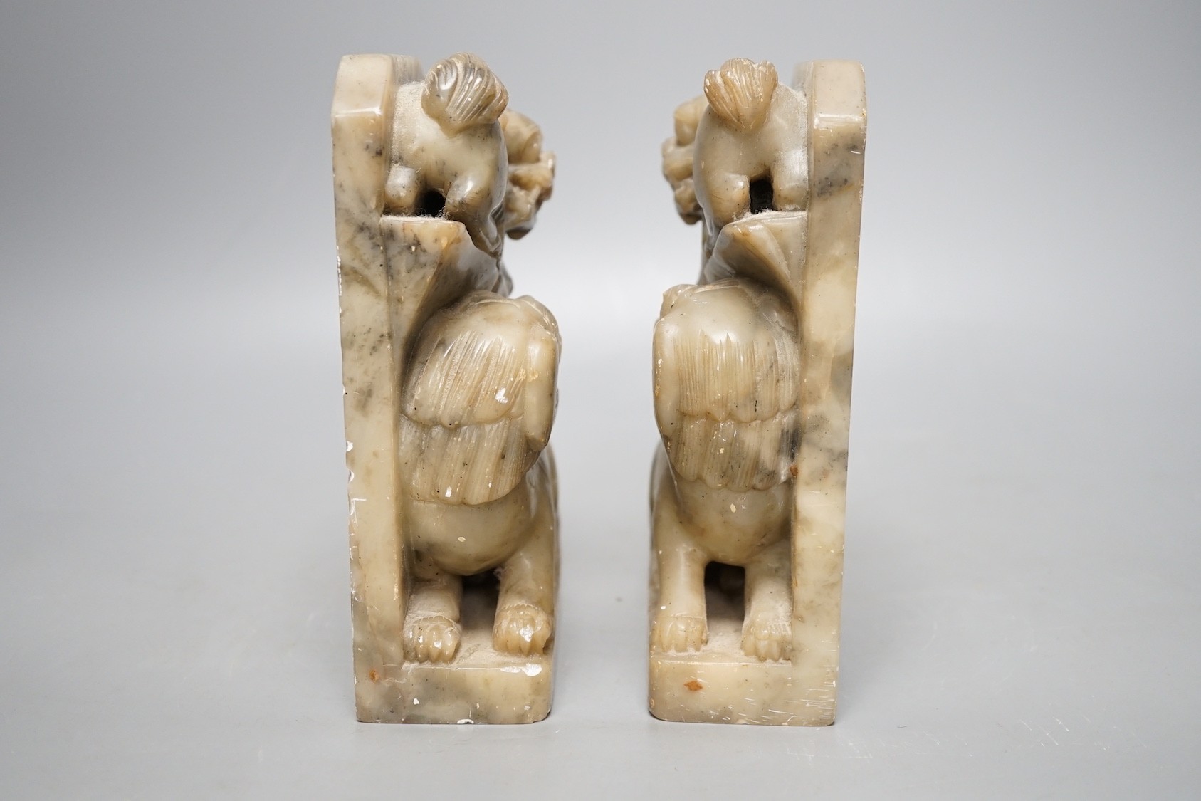 A pair of Chinese soap stone lion dog carvings, 17cm tall